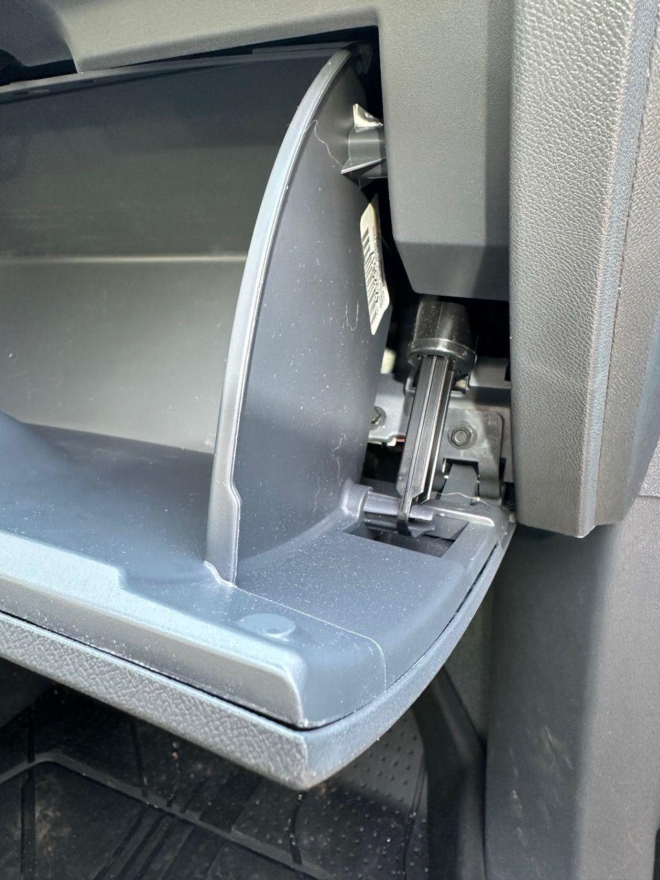 The glove box damper and clip. The glove box is opened.